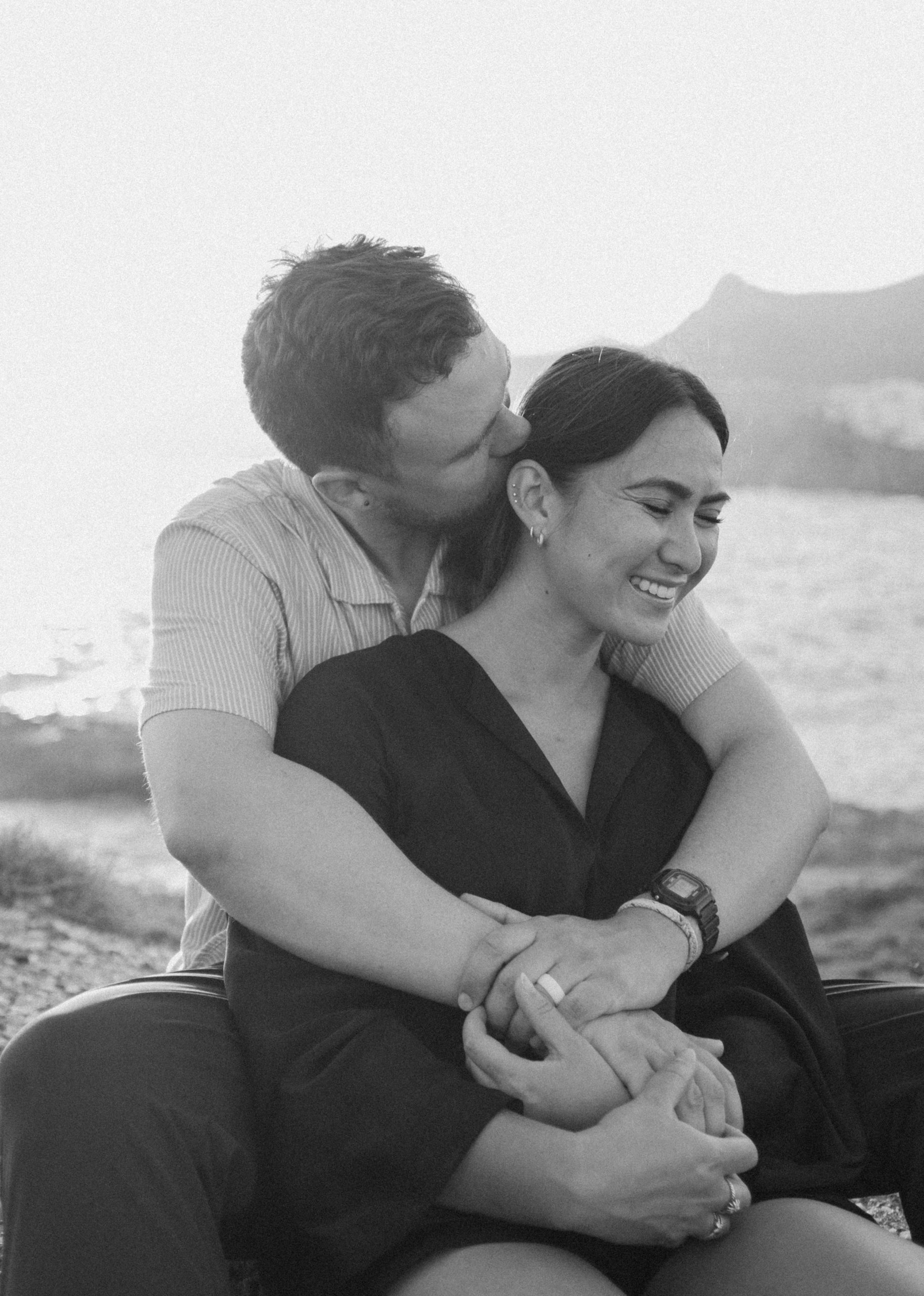Couple kissing on the coast of Greece in b&w