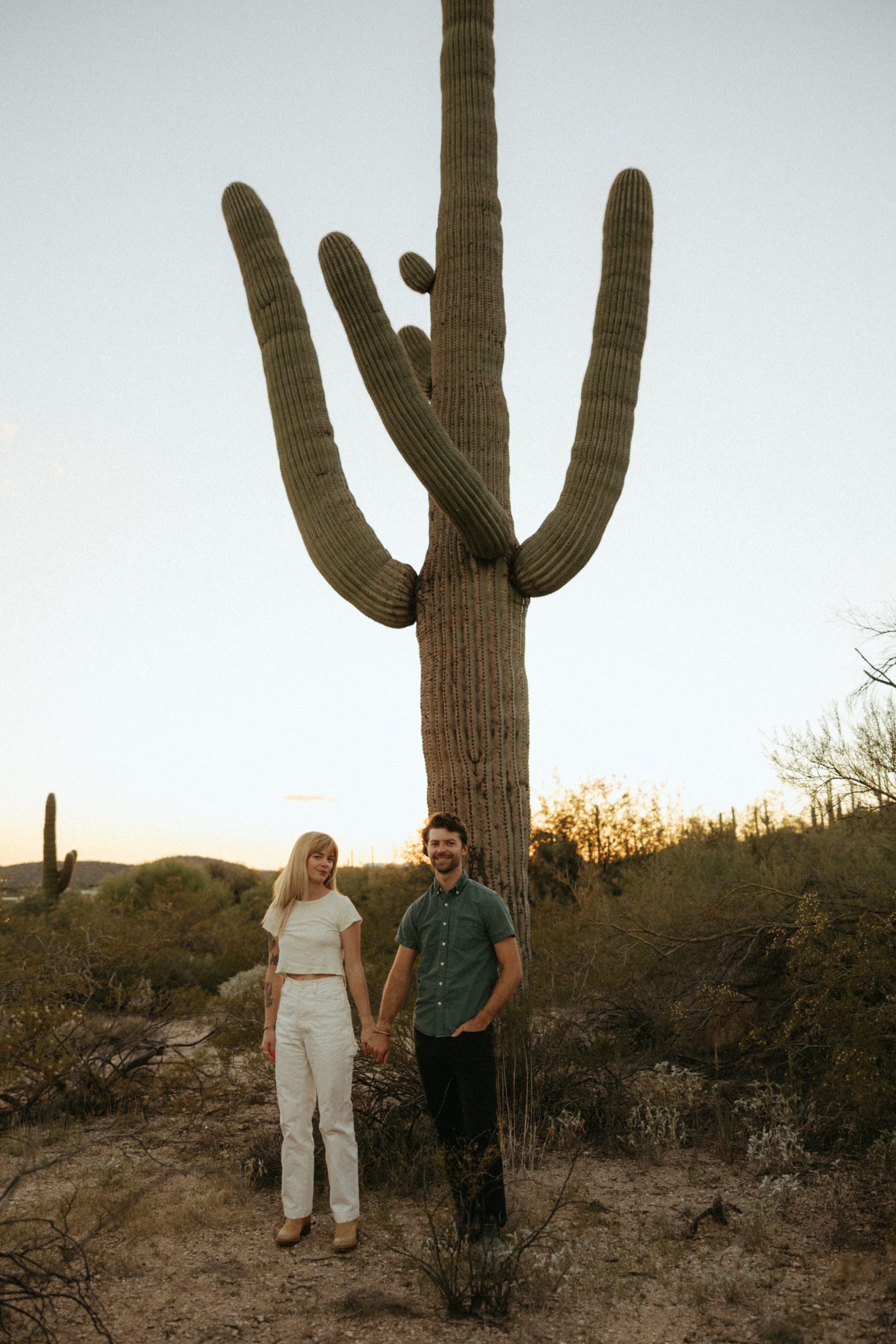 couple standing in front of a cactus